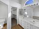 Bathroom featuring dual sinks, vanity, a walk-in closet, and an arched window at 15420 S 29Th St, Phoenix, AZ 85048