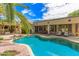 The backyard features a sparkling pool, covered patio, and lush landscaping, creating a private retreat at 15576 W Yucatan Dr, Surprise, AZ 85379