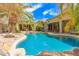 Expansive backyard with a sparkling pool, covered patio, and lush landscaping, creating a private retreat at 15576 W Yucatan Dr, Surprise, AZ 85379