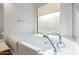 Bathroom features a walk-in tub, large window and chrome faucet at 15576 W Yucatan Dr, Surprise, AZ 85379