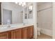 Bathroom with double sinks, wood cabinets, tiled floors, large mirror and a shower/tub combo at 15576 W Yucatan Dr, Surprise, AZ 85379