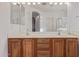 Bathroom boasts a double vanity, tiled floor, framed mirror, and modern lighting at 15576 W Yucatan Dr, Surprise, AZ 85379