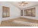 Bedroom with neutral carpet, white walls, vaulted ceiling, and windows framed with wooden shutters at 15576 W Yucatan Dr, Surprise, AZ 85379
