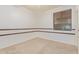 Unfurnished bedroom with neutral carpeting, wood accents, and natural light through the window at 15576 W Yucatan Dr, Surprise, AZ 85379