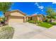 Exterior view of a desert home with a spacious driveway and lush landscaping at 15576 W Yucatan Dr, Surprise, AZ 85379