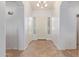 Bright and airy foyer with tile flooring and a modern chandelier at 15576 W Yucatan Dr, Surprise, AZ 85379
