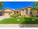 Charming single-story home with desert landscaping, artificial grass, and a two-car garage at 15576 W Yucatan Dr, Surprise, AZ 85379