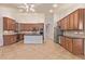 Open kitchen with tile floors, wood cabinetry, and a large center island at 15576 W Yucatan Dr, Surprise, AZ 85379