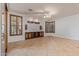 Empty living room featuring neutral tiled flooring, dark wood shutters, and a TV console at 15576 W Yucatan Dr, Surprise, AZ 85379