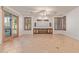 Bright living room with wood-framed windows, sliding glass door, tile flooring and modern ceiling fan at 15576 W Yucatan Dr, Surprise, AZ 85379