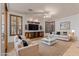 Elegant living room with white sofas, dark wood shutters, and a TV console at 15576 W Yucatan Dr, Surprise, AZ 85379