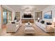 Elegant living room with white sofas, dark wood shutters, and a view of the pool area at 15576 W Yucatan Dr, Surprise, AZ 85379