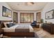 Bright bedroom features a cozy seating area by the windows and plantation shutters at 15576 W Yucatan Dr, Surprise, AZ 85379