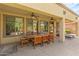 Covered patio with an outdoor dining table with seating for ten, ceiling fans, and desert landscaping at 15576 W Yucatan Dr, Surprise, AZ 85379