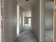 Long hallway showing unfinished drywall and concrete floors, offering a glimpse into the home's layout at 15768 W Beryl Ave, Waddell, AZ 85355