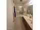 Bright bathroom featuring a glass shower, neutral-toned tiles, and a well-lit vanity with storage at 1652 W Campbell Ave, Phoenix, AZ 85015