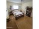 Cozy bedroom featuring hardwood floors, a ceiling fan, a bright window and a wood-framed bed at 1652 W Campbell Ave, Phoenix, AZ 85015