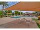 Community pool featuring covered seating, a palm tree, and a nearby building at 1652 W Campbell Ave, Phoenix, AZ 85015