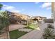 Landscaped backyard with a putting green, pavers, desert landscaping, and a gazebo with an outdoor kitchen at 20408 E Rosa Rd, Queen Creek, AZ 85142