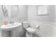 Well-lit half bathroom with a pedestal sink, toilet, and a window with natural light at 20408 E Rosa Rd, Queen Creek, AZ 85142
