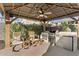 Outdoor gazebo featuring a built-in grill, mini-fridge, sink, bar seating, and a ceiling fan for outdoor entertaining at 20408 E Rosa Rd, Queen Creek, AZ 85142