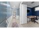 A spacious hallway with blue accent walls, white trim, and tile flooring leading to a private office at 20408 E Rosa Rd, Queen Creek, AZ 85142