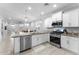 Bright, open kitchen with stainless steel appliances, white cabinetry, and a view into the dining and living areas at 20408 E Rosa Rd, Queen Creek, AZ 85142