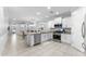 Open-concept kitchen featuring white cabinets, stainless steel appliances, and a center island with bar seating at 20408 E Rosa Rd, Queen Creek, AZ 85142