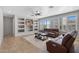 Bright living room with neutral tones, tile flooring, a ceiling fan, and built-in shelving at 2129 E Leo Pl, Chandler, AZ 85249