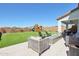 Expansive backyard with lush artificial grass, a playset, and modern patio furniture at 21612 N 60Th Ter, Phoenix, AZ 85054