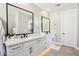 Main bathroom featuring dual vanity sinks, sleek black hardware, and contemporary mirrors at 21612 N 60Th Ter, Phoenix, AZ 85054