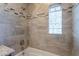 Bathroom featuring a tiled shower and tub with tiled accent border and glass block window at 2318 E Flower St, Phoenix, AZ 85016