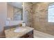 Bathroom featuring granite vanity, large mirror, and tiled shower and tub with tiled accent border and glass block window at 2318 E Flower St, Phoenix, AZ 85016