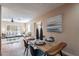 Open-concept dining area with a wooden table, seating, and a glimpse into the bright and airy living room at 2318 E Flower St, Phoenix, AZ 85016