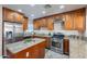 Spacious kitchen with granite countertops, stainless steel appliances, an island, and wooden cabinetry at 2318 E Flower St, Phoenix, AZ 85016