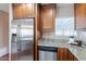 Kitchen showcasing stainless steel appliances, granite countertops, wood cabinets, and a dishwasher at 2318 E Flower St, Phoenix, AZ 85016