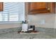 Charming kitchen with granite countertops, wood cabinets, and natural light from the window with blinds at 2318 E Flower St, Phoenix, AZ 85016