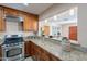 Updated kitchen with granite countertops, wood cabinets, stainless appliances, and an open view to the living area at 2318 E Flower St, Phoenix, AZ 85016