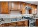 Well-equipped kitchen with wood cabinets, granite countertops, stainless steel appliances, and a double sink at 2318 E Flower St, Phoenix, AZ 85016