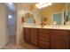 Bathroom with dual sinks, wood cabinets, and decorative accents at 2408 E Fiesta Dr, Casa Grande, AZ 85194