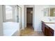 Bright bathroom featuring a soaking tub, glass shower, and a walk-in closet at 25564 W Magnolia St, Buckeye, AZ 85326