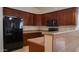 Well-equipped kitchen featuring rich wood cabinetry and modern appliances, including a refrigerator and microwave at 25564 W Magnolia St, Buckeye, AZ 85326