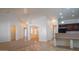 Bright, open living room with neutral tile flooring leading to a dining area at 25564 W Magnolia St, Buckeye, AZ 85326