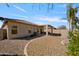 View of the home's backyard with covered patio, rock landscaping and privacy wall at 2910 W Allens Peak Dr, San Tan Valley, AZ 85144