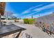 A gravel-covered backyard with a block wall, colorful metal flowers, and a trimmed hedge under a vibrant blue sky at 3702 W Megan St, Chandler, AZ 85226