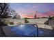 Inviting pool with rock feature and metal railing for easy access, set against a scenic sky backdrop at 3702 W Megan St, Chandler, AZ 85226