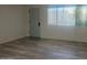 Bright living room features wood-look flooring and natural light from a large window at 5518 E Lindstrom Ln # B3, Mesa, AZ 85215