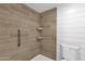 Beautifully designed shower with sleek tile, a handrail, and convenient shelving for storage at 623 W Guadalupe Rd # 131, Mesa, AZ 85210