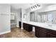 Bathroom featuring dual sinks, dark wood cabinets, a large mirror, and a shower at 647 E Palomino Way, San Tan Valley, AZ 85143