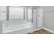 Bathroom featuring a soaking tub with a shower and glass door at 647 E Palomino Way, San Tan Valley, AZ 85143